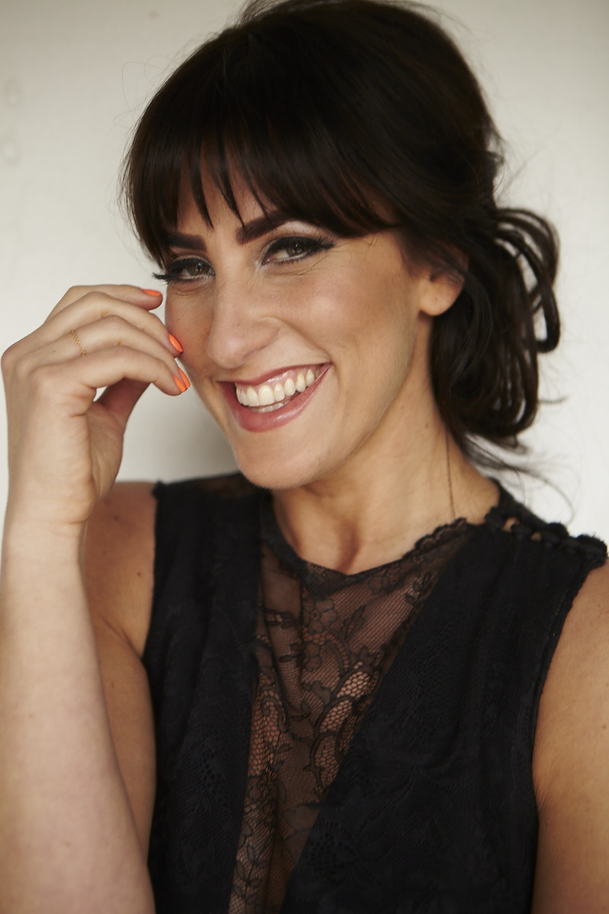 Lucinda Belle smiling warmly in a black lace dress